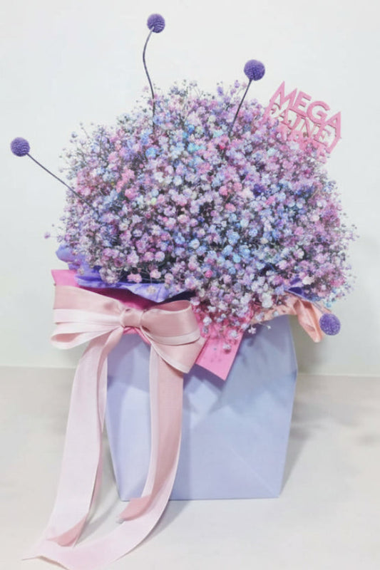 „Kanciasty flower box z kolorową gipsówką w odcieniach różu, fioletu i błękitu, w niebieskim pudełku z kokardą .”